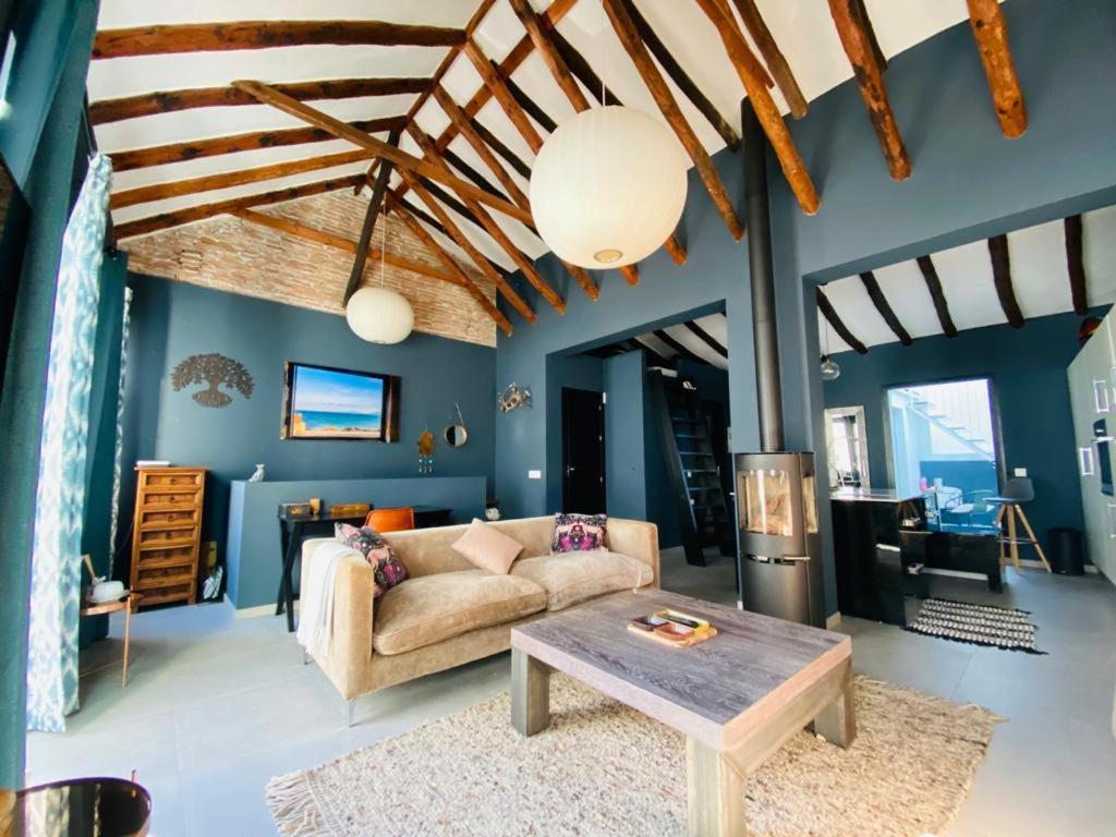Living room with wood beams, blue walls, and a stove