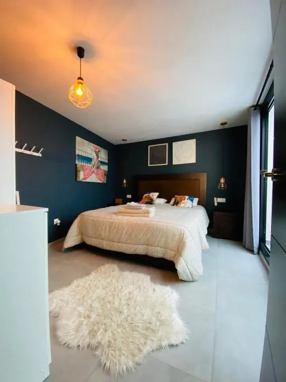 Bedroom with deep blue walls and a king bed